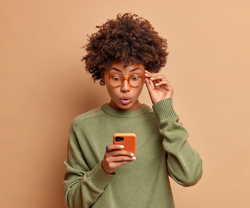 Joven sorprendido mirando su celular