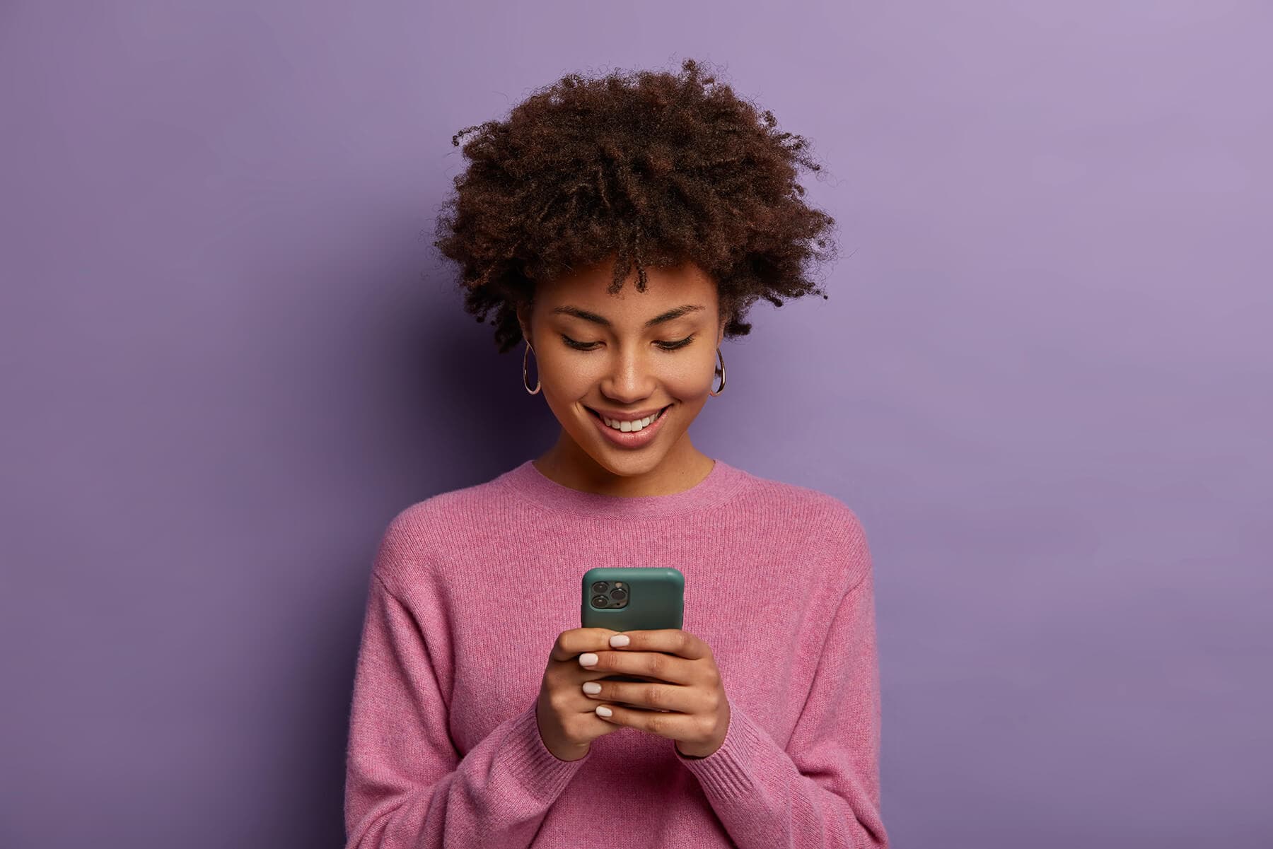 Mujer joven sonriendo con su celular nuevo
